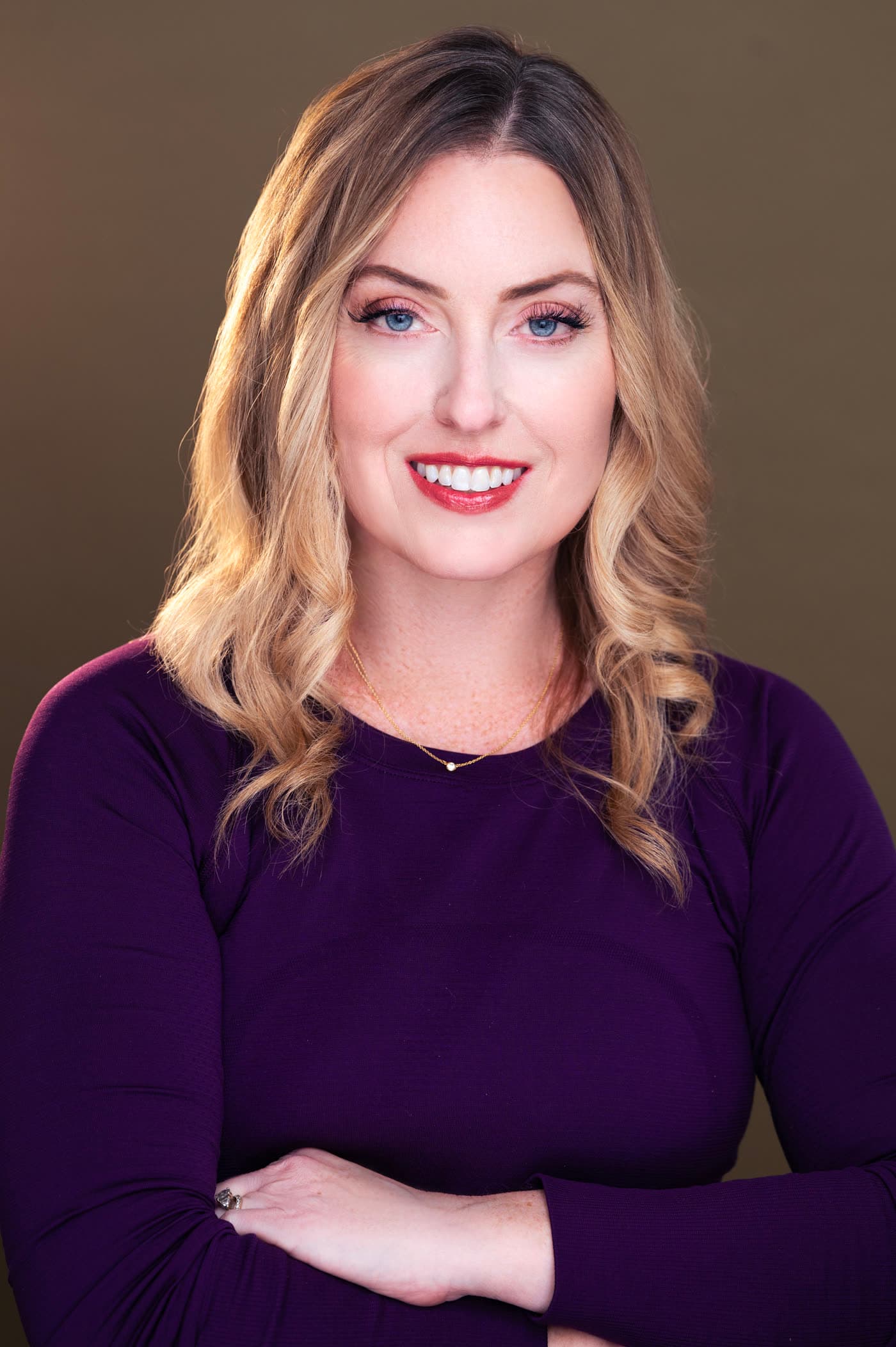 Portrait of Audra, arms crossed, in a purple top
